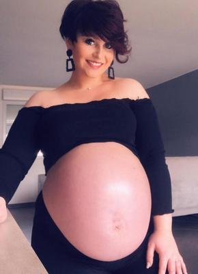 Mujer [embarazada] muy orgullosa de lucir su gran barriga