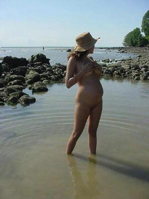 [Pregnant] young woman showing off on beach